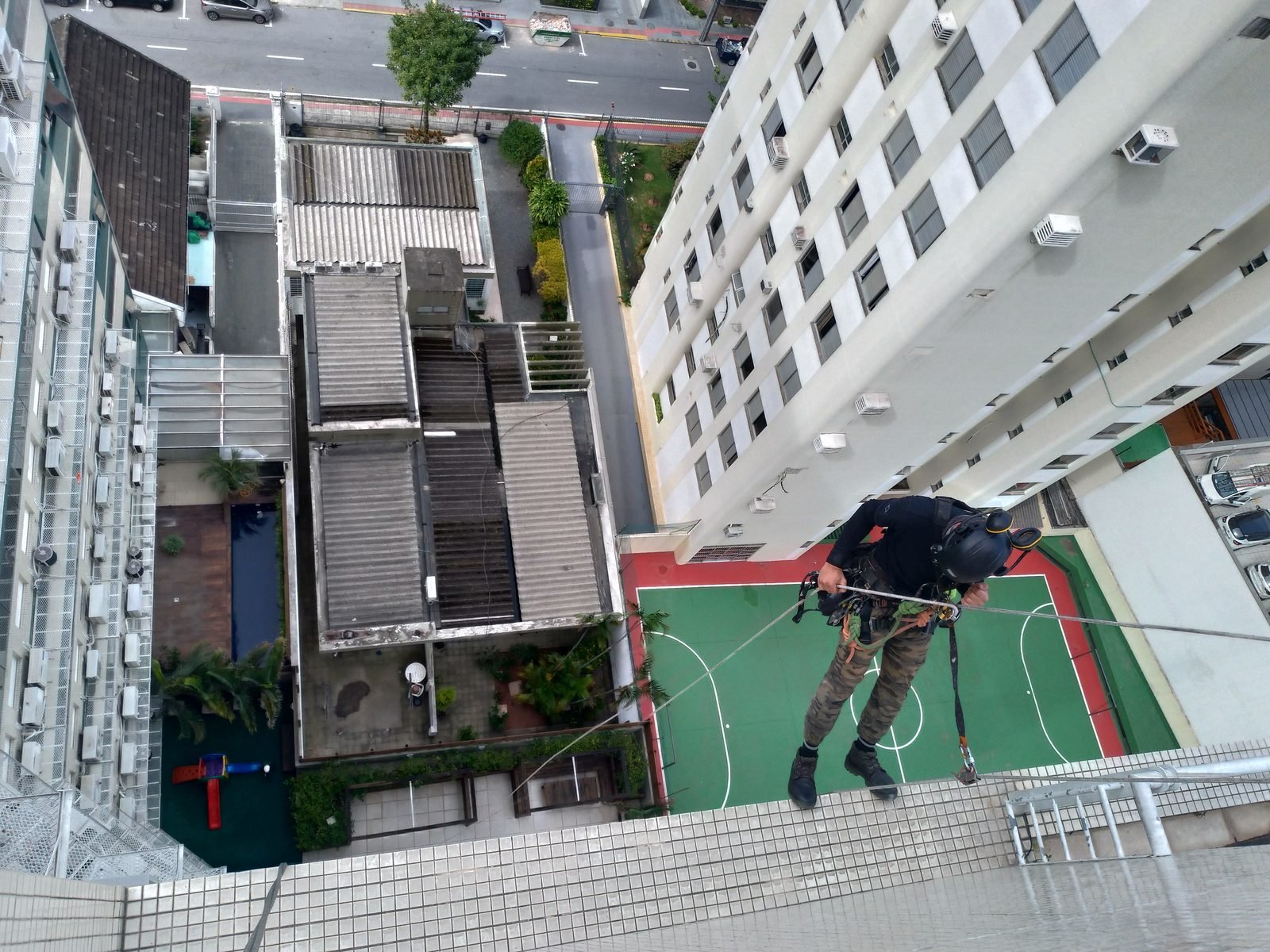 Profissional descendo por corda na fachada de um edifício alto